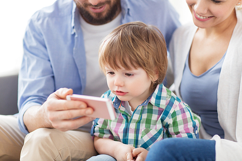 family, technology and people concept - happy mother, father and little boy with smartphone at home