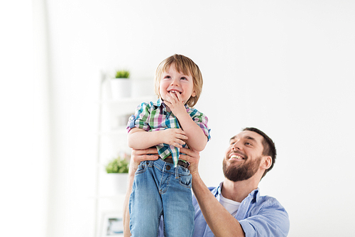 family, adoption and people concept - happy father and son having fun at home