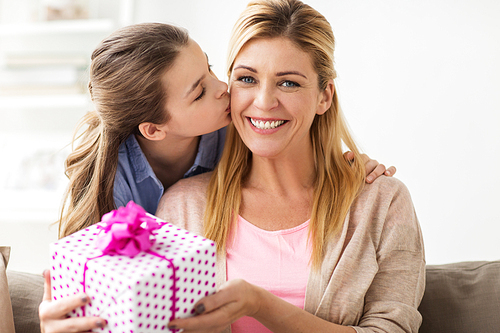 people, holidays and family concept - happy girl giving birthday present to mother at home