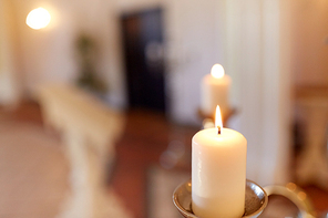 religion and christianity concept - candles burning in church