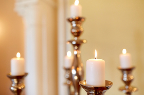 religion concept - candles burning in church