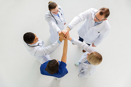 medicine, healthcare, gesture, success and people concept - group of happy doctors making high five at hospital