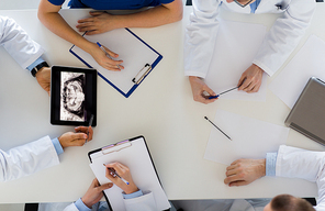 medicine, healthcare and oral surgery concept - group of doctors or surgeons discussing jaw x-ray on tablet pc computer screen at hospital or face and jaw surgery center