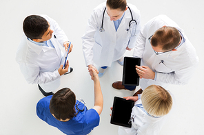 medicine, healthcare and gesture concept - group of doctors with tablet pc computers greeting by handshake at hospital