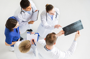medicine, healthcare and surgery concept - group of doctors or surgeons with spine x-ray and clipboards at hospital