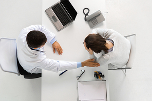 medicine, healthcare and people concept - doctor with laptop computer and young woman patient meeting at hospital