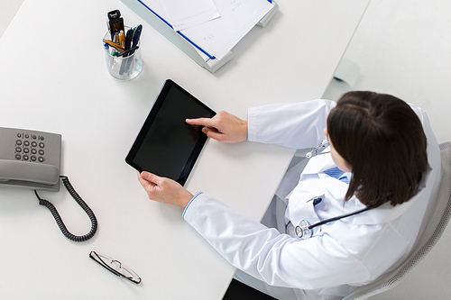 medicine, healthcare and people concept - doctor with tablet pc computer at table in clinic