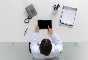 medicine, healthcare and people concept - doctor with tablet pc computer at table in clinic