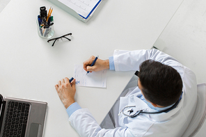 medicine, healthcare and people concept - doctor hands with prescription at table in clinic