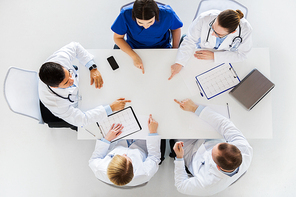 medicine, healthcare and cardiology concept - group of doctors with cardiograms, clipboards and laptop computer showing something imaginary on table