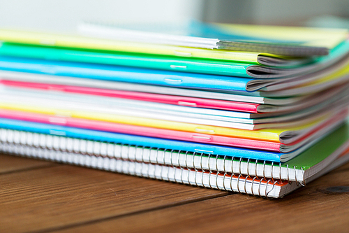 education, school supplies and object concept - close up of notebooks on wooden table