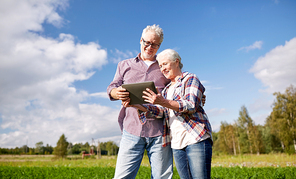 farming, gardening, agriculture and people concept - happy senior couple with tablet pc computer at summer farm