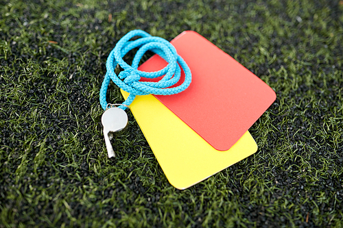sport, soccer and game - whistle and caution cards on football field