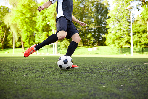 sport, football and people concept - soccer player playing with ball on field