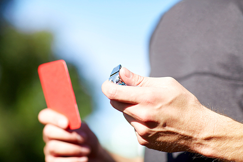 sport, soccer, caution, game and people concept - referee hands with whistle and red card on football field