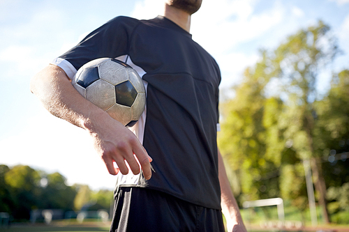 sport, football training and people - close up of soccer player with ball on field