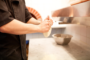 cooking, baking and people concept - chef hands preparing dough on table at kitchen
