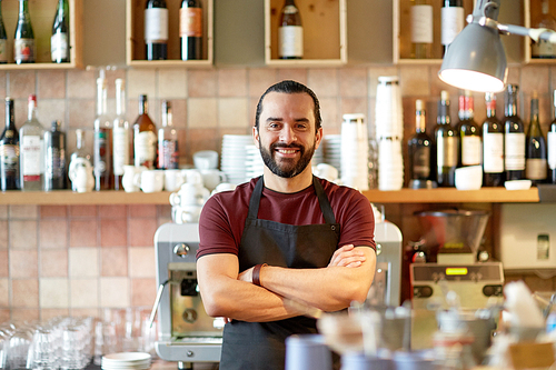 small business, people and service concept - happy man or waiter in apron at bar or coffee shop
