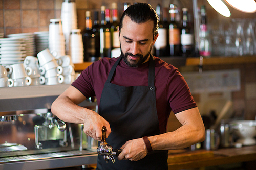 occupation, people and service concept - barista man making espresso at bar or coffee shop