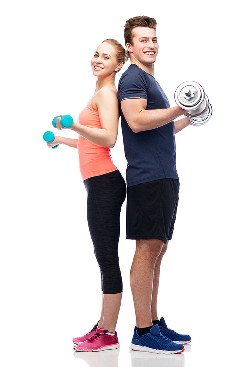 sport, fitness, lifestyle and people concept - happy sportive man and woman with dumbbells flexing muscles