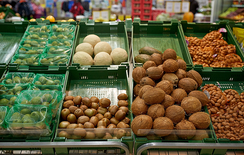 food and sale concept - fruits, nuts and vegetables on stall at grocery store or market