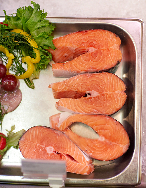 seafood, sale and food concept - chilled fresh salmon fish fillet in metal tray on ice at grocery store