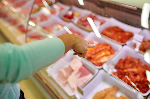 people, shopping, sale and food concept - customer hand pointing at meat on grocery stall