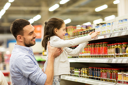 family, sale, shopping, consumerism and people concept - happy father with child buying food at grocery store