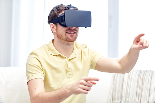 technology, gaming, entertainment and people concept - happy young man with virtual reality headset or 3d glasses playing video game