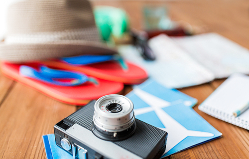 summer vacation, travel, tourism  and objects concept - close up of camera, airplane tickets and personal accessories