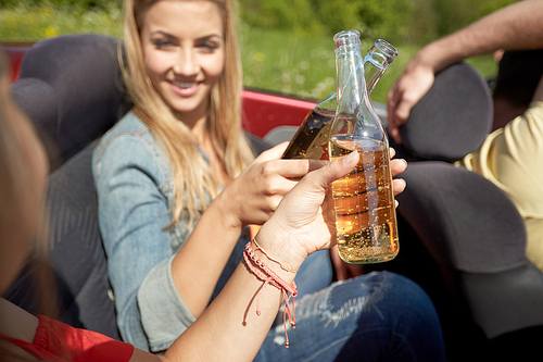 summer holidays, road trip, vacation, travel and people concept - happy young women with fizzy drinks driving in convertible car