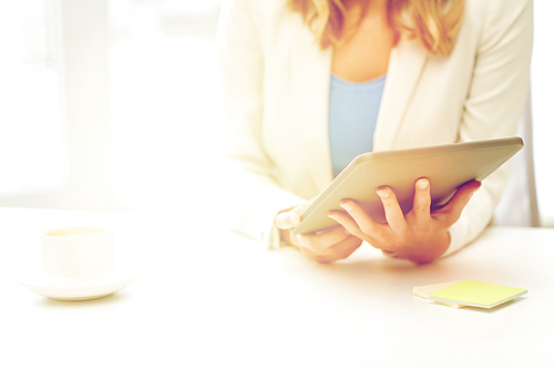 education, business and technology concept - close up of businesswoman or student with tablet pc computer and coffee cup at office table