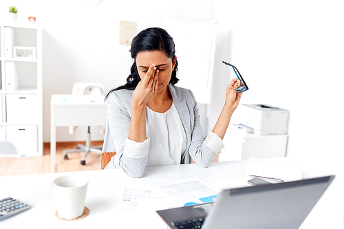 business, overwork, deadline, vision and people concept - tired businesswoman with glasses working at office and rubbing eyes