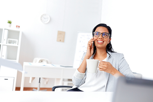 business, communication and people concept - happy businesswoman or secretary calling on smartphone and drinking coffee at office
