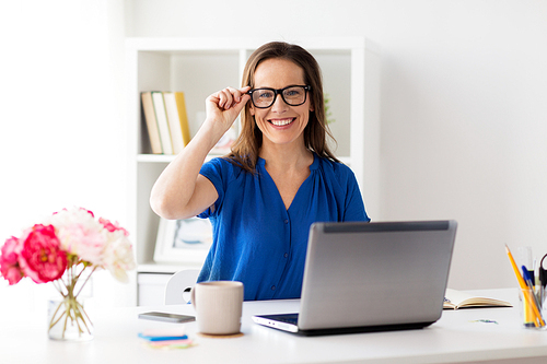 business, vision and people concept - happy smiling woman with laptop computer working at home or office