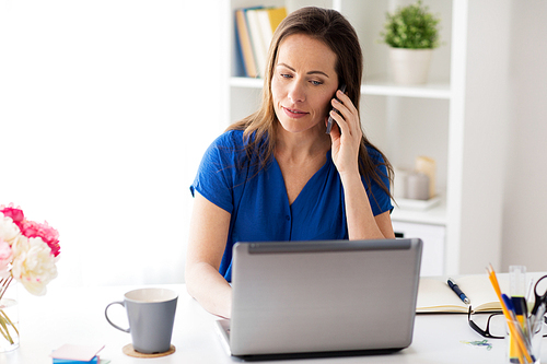 technology, communication and people concept - happy woman calling on smartphone at office or home