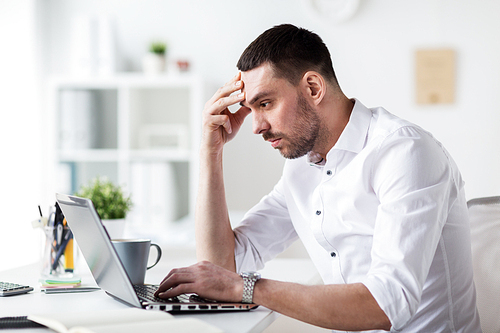 business, people, deadline and technology concept - stressed businessman with laptop computer at office