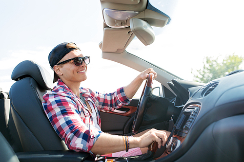 summer holidays, travel, road trip and people concept - happy young man driving convertible car with manual transmission