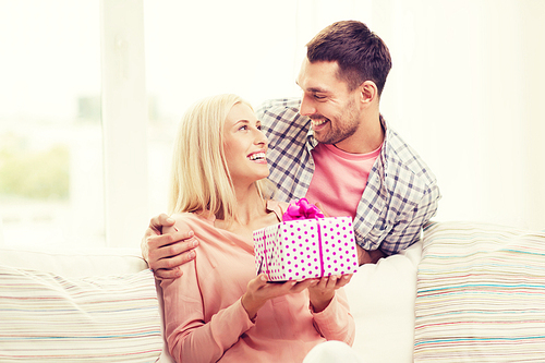 relationships, love, people, birthday and holidays concept - happy man giving woman gift box at home
