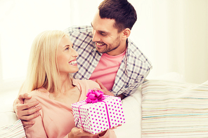 relationships, love, people, birthday and holidays concept - happy man giving woman gift box at home