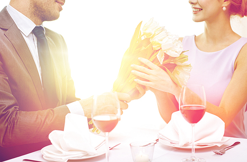 restaurant, people, celebration and holiday concept - smiling young couple with glasses of red wine looking at each other at restaurant