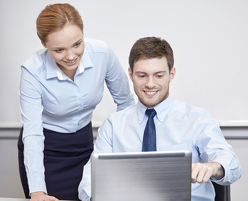 business, people, technology and teamwork concept - smiling businessman and businesswoman with laptop computer meeting and talking in office