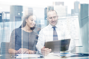 business, people, technology and teamwork concept - smiling businessman and businesswoman with tablet pc computer meeting in office