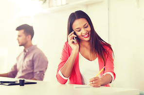 business, startup, communication and people concept - happy african american businesswoman or creative worker calling on smartphone at office