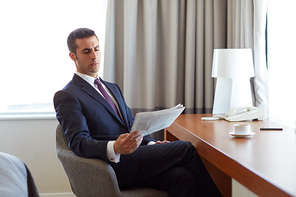 business, people and mass media concept - businessman reading newspaper and  coffee at hotel room