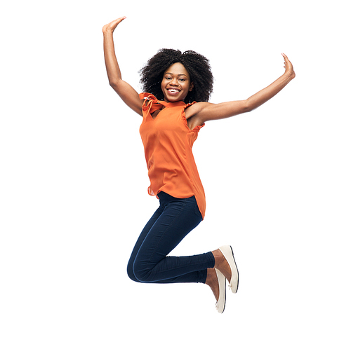 people, race, ethnicity and motion concept - happy african american young woman jumping over white