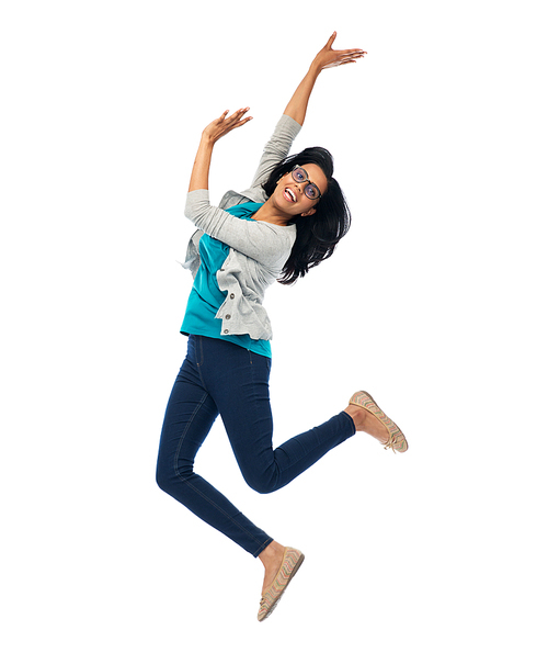 happiness, freedom, motion and people concept - smiling young indian woman jumping in air