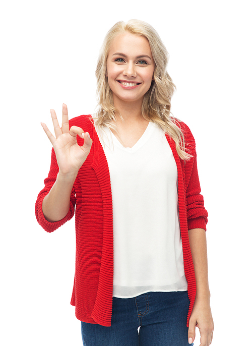 gesture, fashion, portrait and people concept - happy smiling young woman in red cardigan showing ok hand sign over white