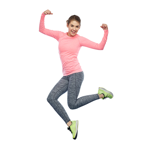 sport, fitness, motion and people concept - happy smiling young woman jumping in air and showing power gesture over white background