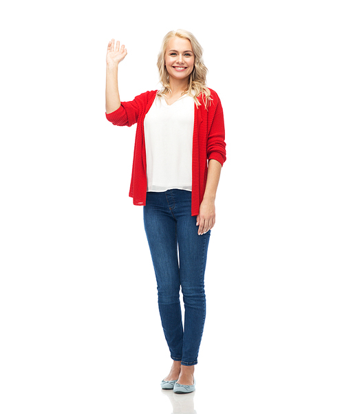 gesture, fashion, portrait and people concept - happy smiling young woman in red cardigan waving hand over white